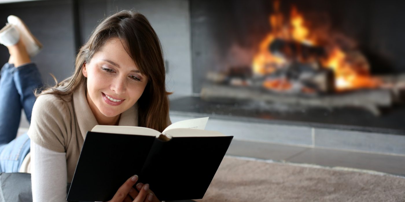 Women reading in front of fireplace