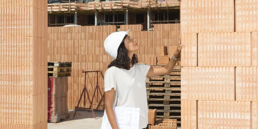Female architect checking door frame on construction site