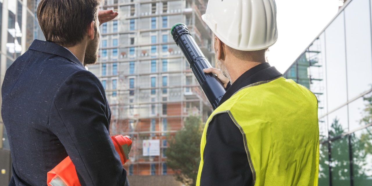 Businessman and architect talking about a new building project at a construction site