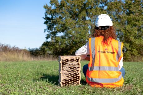 Blocco in laterizio sostenibilità nel verde con persona di spalle