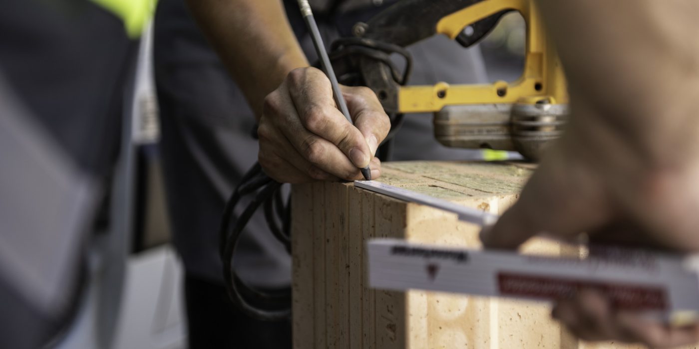 Field service employee at construction site supporting building professional in front of van