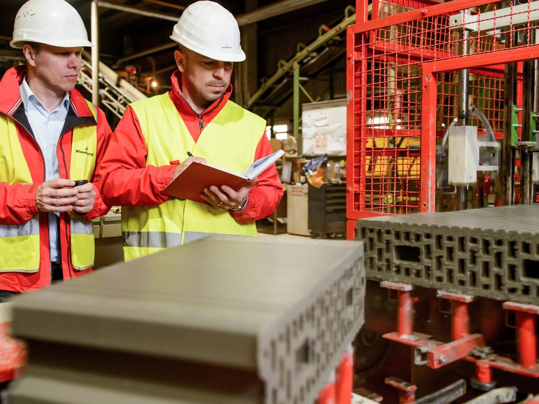 quality control, two men with white helmets and safety jacket inspecting production line
