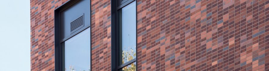 Architect or designer comparing brick sample in front of computer screen