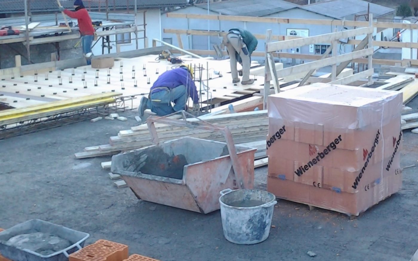Construction workers to installing Porotherm clay blocks to renovation of multi family house Aosta